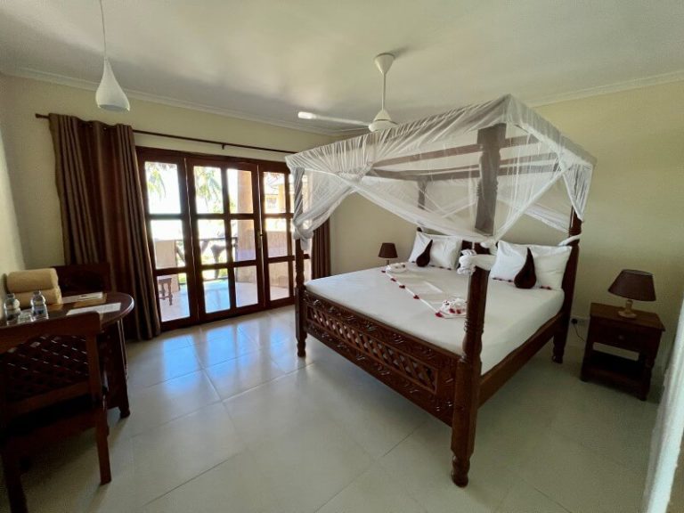 Deluxe Double room with carved four-poster bed at Zula Zanzibar