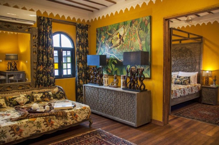 Living area of a Kholle House apartment with patterned sofa and wall mural