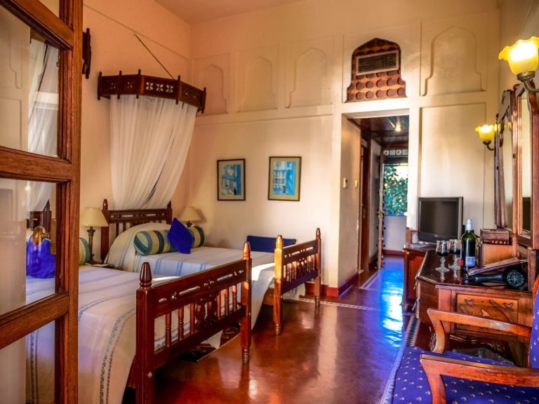 Prime room with carved wooden furniture and Swahili details at Zanzibar Serena Hotel