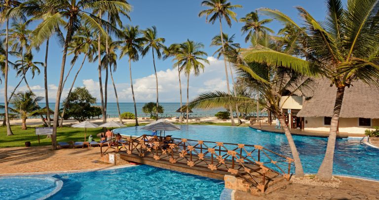 Lagoon pool with footbridge and palm trees at Ocean Paradise Resort