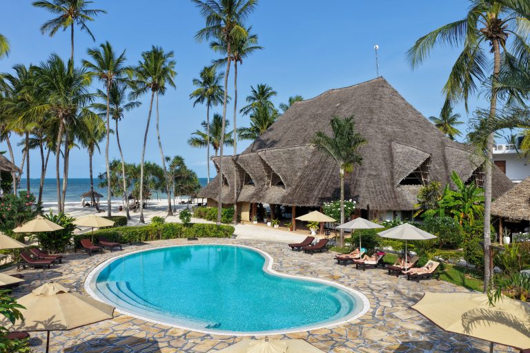 Kidney-shaped pool beside the main thatched building at Pongwe Bay Resort