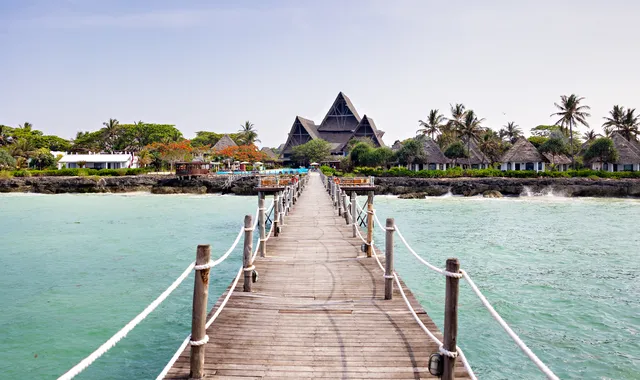 Jetty over turquoise water looking back to Essque Zalu Zanzibar