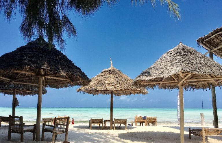 Thatched umbrellas on Paje beach in front of Dhow Inn