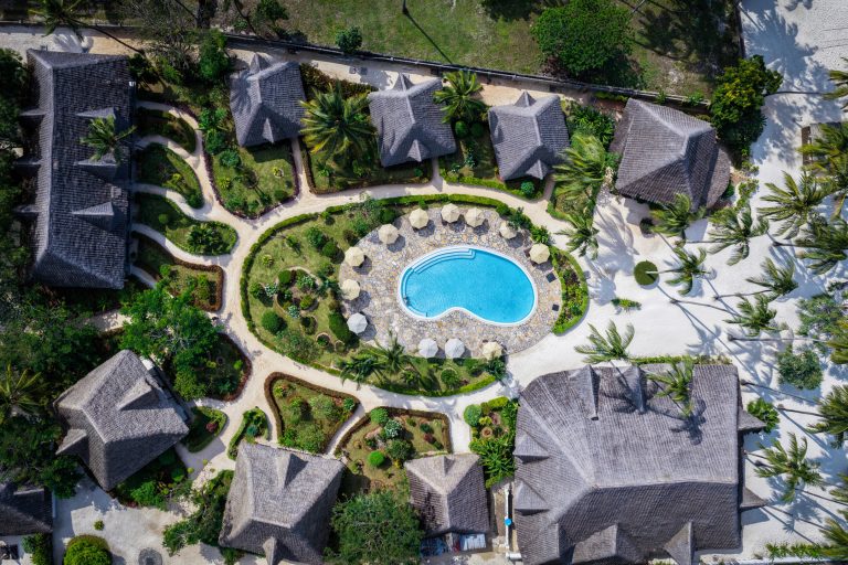 Pool surrounded by gardens and thatched villas at Pongwe Bay Resort