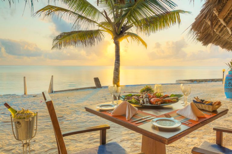Seafood dinner on the beach at sunset at Bluebay Beach Resort
