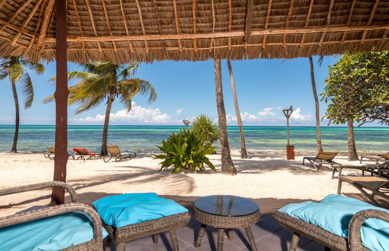 Beach view from a shaded lounge with blue cushions at Karafuu Beach Resort