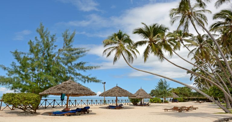 Thatched umbrellas on the white beach at Ocean Paradise Resort