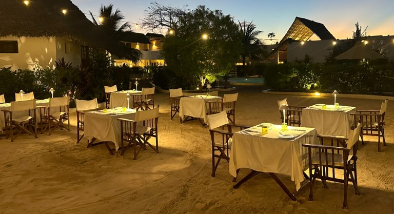 Candlelit tables on the sand at Dhow Inn's restaurant in the evening