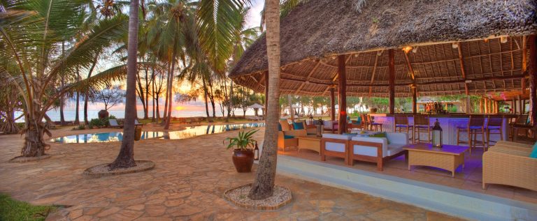 Thatched pool bar lit at dusk at Bluebay Beach Resort