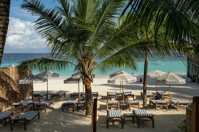 Private beach area with loungers and umbrellas at The Z Hotel