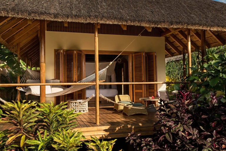 Bungalow with thatched roof and terrace hammock in the garden at Zuri Zanzibar