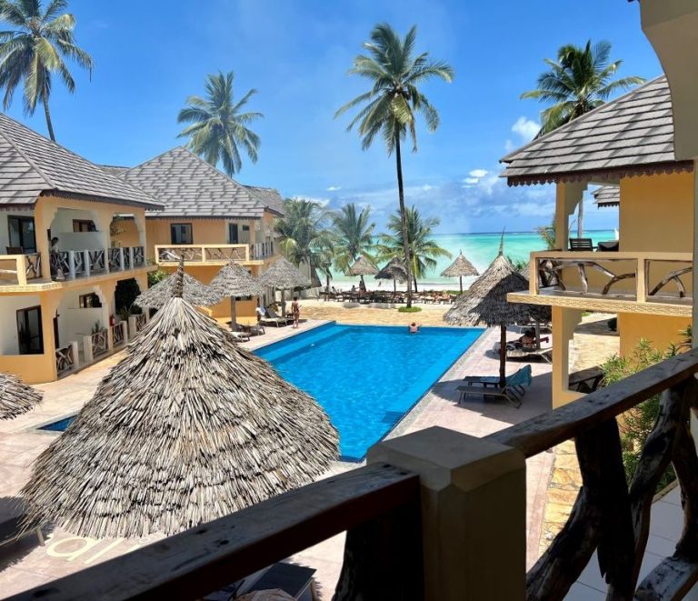 Pool and beach bar under thatched umbrellas from a balcony at Mahali Zanzibar