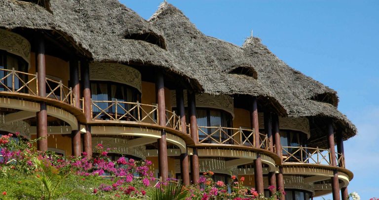 Two-storey makuti-roofed roundhouse rooms with balconies at Ocean Paradise Resort