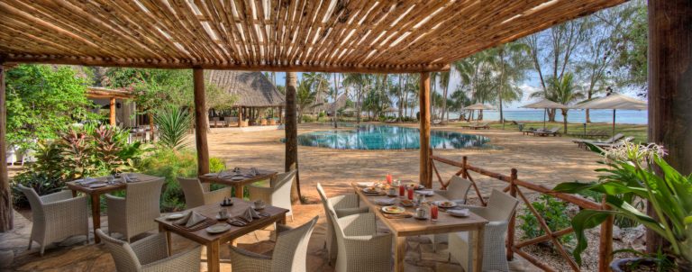 Terrace restaurant overlooking the pool and palms at Bluebay Beach Resort