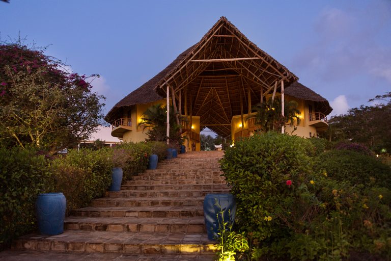 Lit stone steps to the thatched reception at Gold Zanzibar at dusk