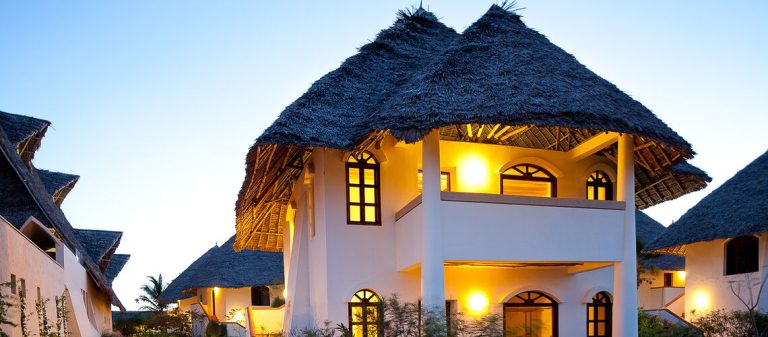 Thatched two-storey suite building at Essque Zalu Zanzibar at dusk