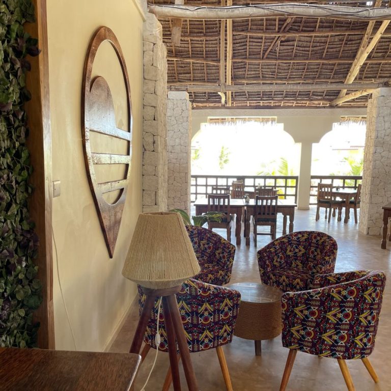 Lounge with patterned armchairs and sea-view terrace at Mahali Zanzibar