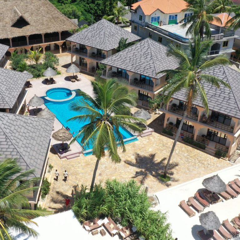 Pool surrounded by sun loungers and palms at Mahali Zanzibar, seen from above