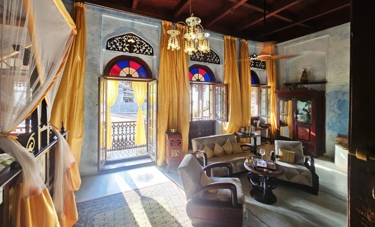 Sitting room with chandelier and stained-glass doors at Emerson Spice Hotel