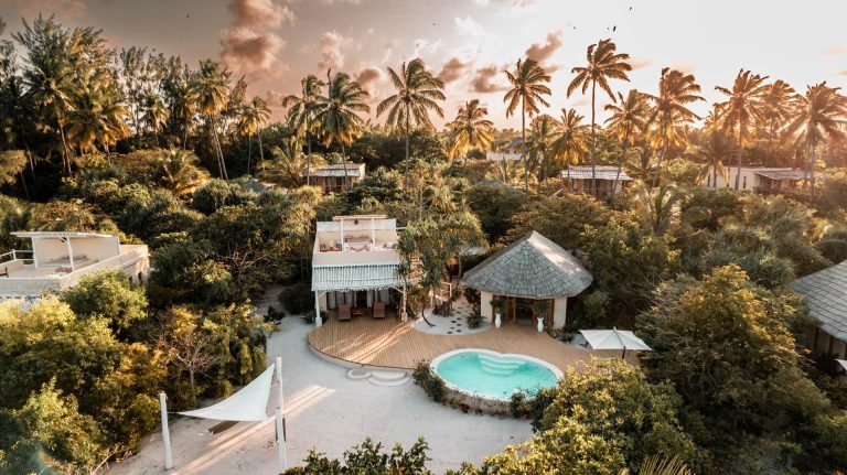 Aerial view at sunset of villas and pools among palms at Zanzibar White Sand Luxury Villas