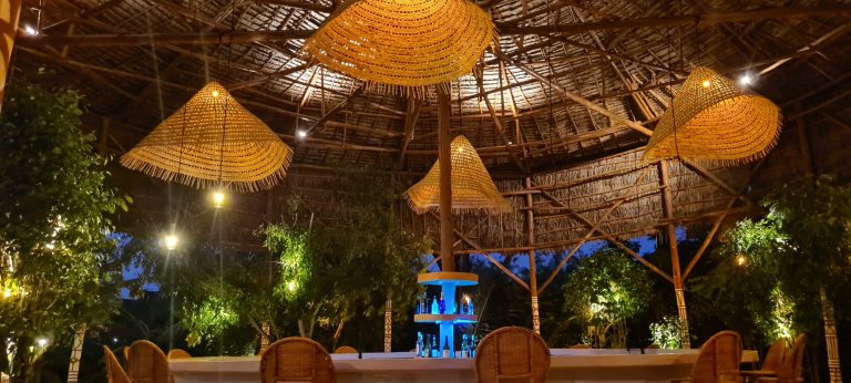 Thatched restaurant and lounge lit at night at Yasa Boutique Hotel, Nungwi