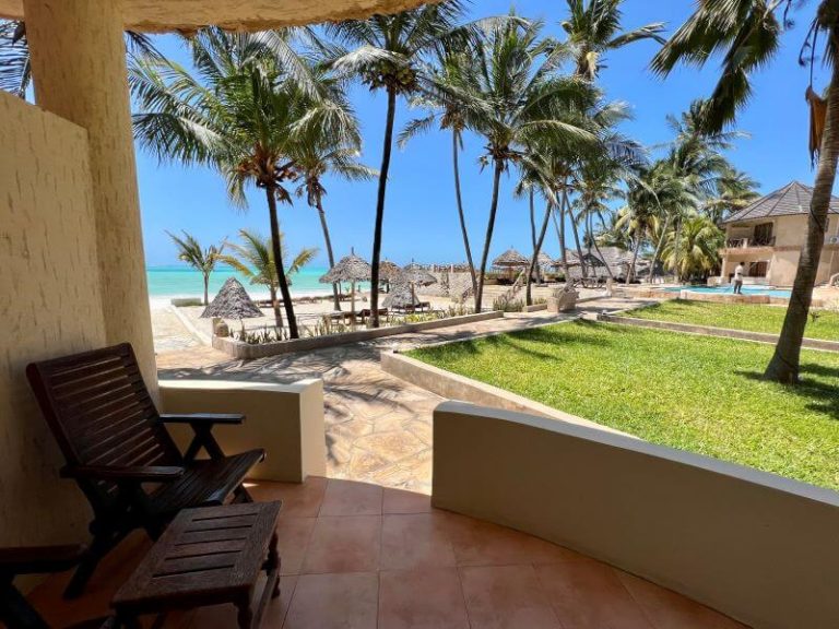 Ground-floor terrace with lounger facing the pool and sea at Zula Zanzibar