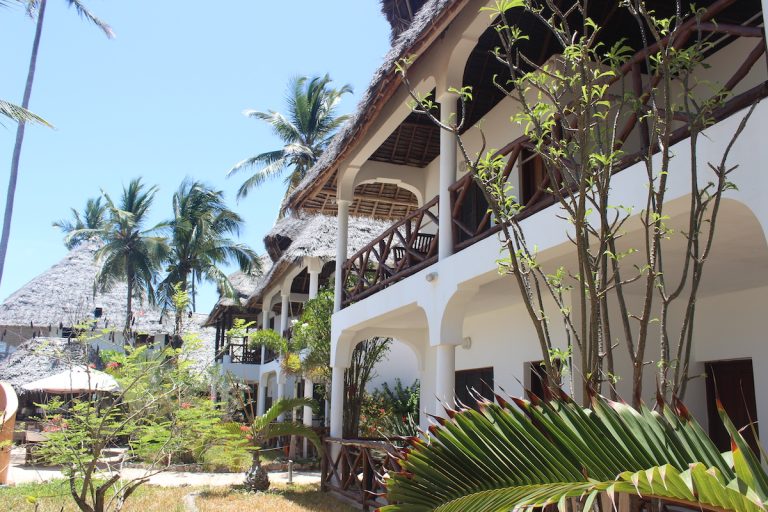Whitewashed two-storey room block with arched verandas at Blue Oyster Hotel