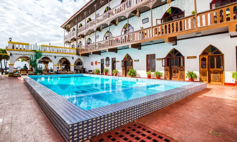Main courtyard pool surrounded by carved wooden balconies at Tembo House Hotel