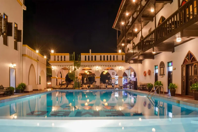 Courtyard pool of Tembo House Hotel lit up at night