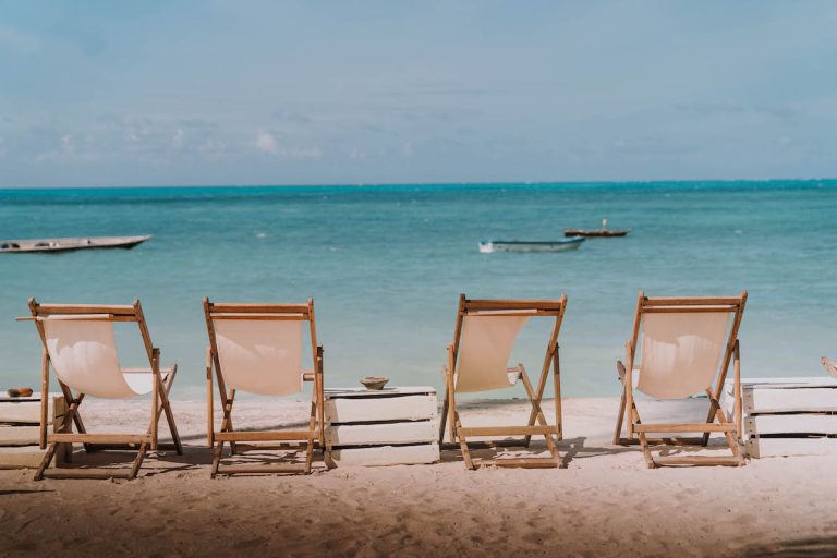 Deck chairs on the white beach in front of Blue Oyster Hotel