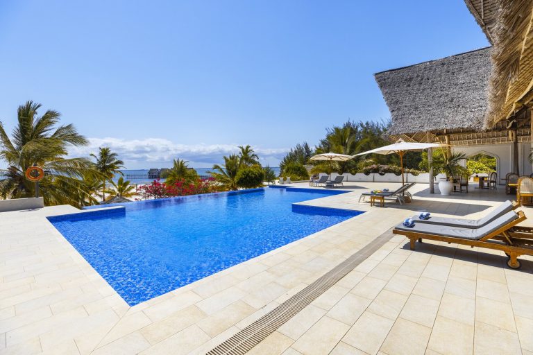 Infinity pool with sun loungers and sea view at Konokono Beach Resort