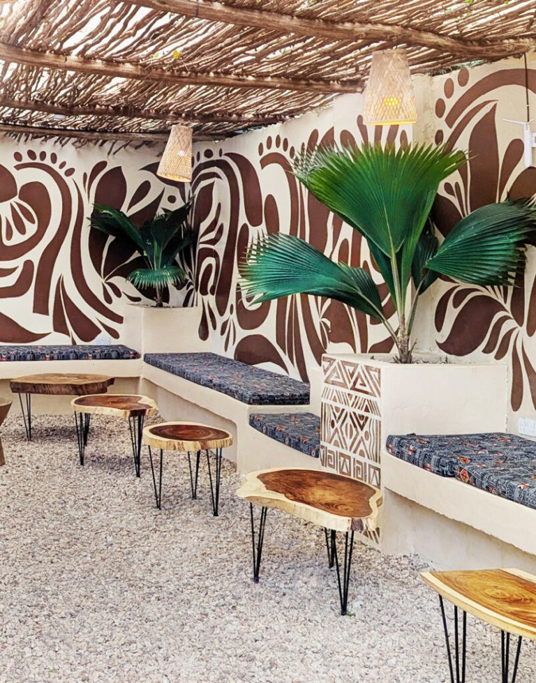 Lounge with patterned walls and plants at Yasa Boutique Hotel, Nungwi