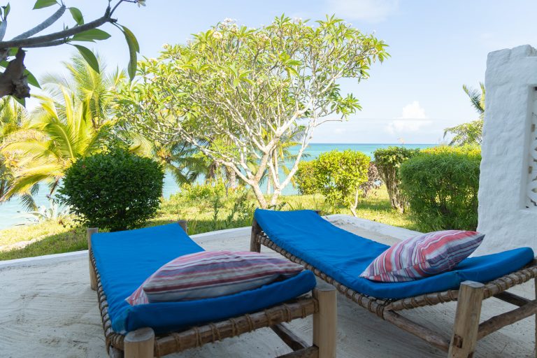 Blue-cushioned daybeds facing the sea at Shooting Star Boutique Hotel