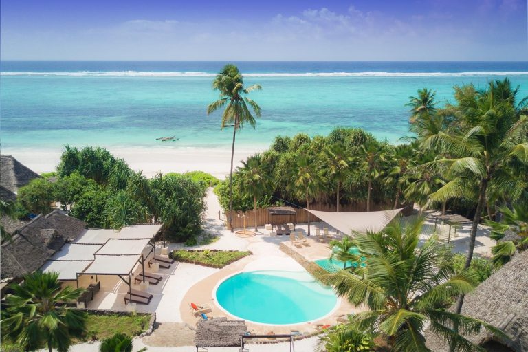 Aerial view of the pool and gardens at Zanzibar Pearl with the ocean behind